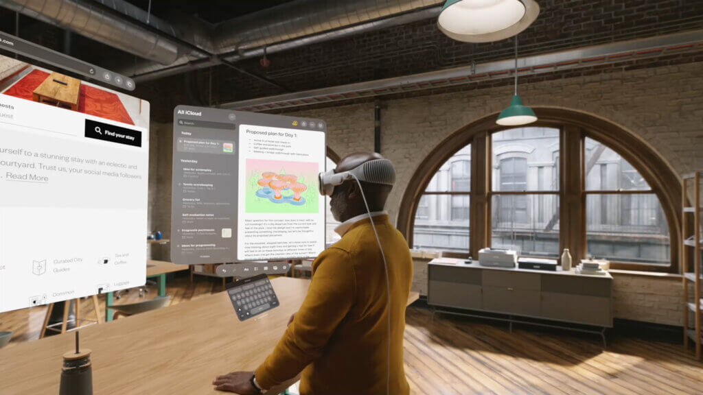 Frau steht mit der Vision Pro von Apple in einem Raum und schaut virtuelle Bildschirme an